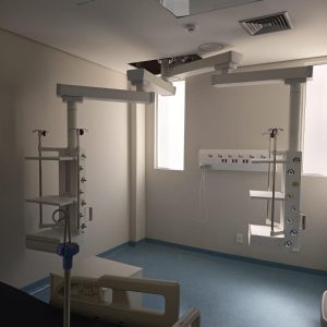 Estativas Med Light com braços e prateleiras em quarto hospitalar